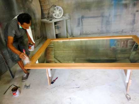 Atlier de l'artisan ébéniste Kohé design Bali, vernissage d'un cadre en bois exotique sur mesure.