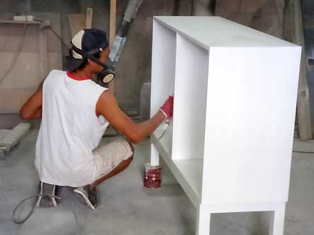 Peinture en blanc d'un meuble sur mesure dans l'atelier Kohé design Bali , artisan cuisiniste en Indonésie.